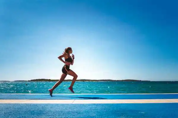 Woman running showing strong leg muscle Brighton